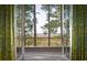 View from balcony surrounded by green patterned curtains; trees and the marsh visible beyond at 83 Blue Heron Pond Rd, Kiawah Island, SC 29455