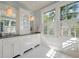 Bright bathroom with dual vanity, abundant cabinetry, tiled floor, and large windows with shutters at 83 Blue Heron Pond Rd, Kiawah Island, SC 29455