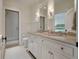 A well-lit bathroom with a double sink vanity, neutral countertops, and a glass shower at 83 Blue Heron Pond Rd, Kiawah Island, SC 29455