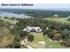 Aerial shot of a grand clubhouse overlooking a golf course, a bass pond, and the ocean in the distance at 83 Blue Heron Pond Rd, Kiawah Island, SC 29455