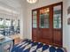 Elegant entryway with hardwood floors, shiplap walls, and stylish double doors with glass panes to the front porch at 83 Blue Heron Pond Rd, Kiawah Island, SC 29455