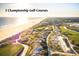 Aerial view of a stunning golf course with manicured greens, sandy bunkers, and ocean views in the background at 83 Blue Heron Pond Rd, Kiawah Island, SC 29455