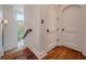 Hallway with hardwood floors, sconce lighting, wainscoting, and arched doors with matte black hardware at 83 Blue Heron Pond Rd, Kiawah Island, SC 29455