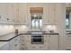 A kitchen featuring custom cabinets, wood floors, and views of the yard at 83 Blue Heron Pond Rd, Kiawah Island, SC 29455