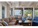 Inviting living room with stylish furniture, ample natural light, and serene views of the beach beyond the palm trees at 83 Blue Heron Pond Rd, Kiawah Island, SC 29455