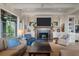Comfortable living room featuring a fireplace, built-in cabinets, and windows offering beautiful views of the property at 83 Blue Heron Pond Rd, Kiawah Island, SC 29455