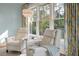 Relaxing living room with two white recliners, side table, large window with view, and unique floor lamp at 83 Blue Heron Pond Rd, Kiawah Island, SC 29455