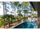 Stunning in-ground pool with a waterfall and lush landscaping surrounded by native trees and natural areas at 83 Blue Heron Pond Rd, Kiawah Island, SC 29455