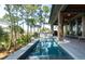 Beautiful in-ground pool with stone waterfall feature and poolside seating overlooking the wooded scenery at 83 Blue Heron Pond Rd, Kiawah Island, SC 29455