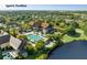 Aerial view showcasing a community pool and a sports pavilion with lush trees and landscaping at 83 Blue Heron Pond Rd, Kiawah Island, SC 29455