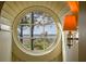 Close up of round window with view of the water and trees, framed by light wood paneling at 83 Blue Heron Pond Rd, Kiawah Island, SC 29455