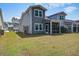 A home's backyard featuring a screened porch, healthy green grass, and landscaping at 832 Descartes St, Summerville, SC 29486