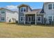 View of a home's backyard with a screened porch and well-maintained lawn at 832 Descartes St, Summerville, SC 29486