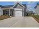 Charming home featuring a spacious driveway and a white garage door, complimented by front yard landscaping at 832 Descartes St, Summerville, SC 29486