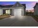 Charming home featuring a spacious driveway and a white garage door, set against a beautiful sunset at 832 Descartes St, Summerville, SC 29486
