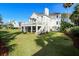 Expansive backyard with lush green lawn, deck, screened in porch, and staircase at 9 Intracoastal Ct, Isle of Palms, SC 29451