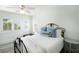 Well-lit bedroom with a white ceiling fan, white comforter, and black metal bed frame at 9 Intracoastal Ct, Isle of Palms, SC 29451