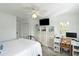 Bright bedroom with ceiling fan, TV, storage shelves, desk, and chair provides a cozy and functional living space at 9 Intracoastal Ct, Isle of Palms, SC 29451