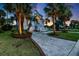 A charming home is highlighted by palm trees and tasteful landscaping at dusk at 9 Intracoastal Ct, Isle of Palms, SC 29451