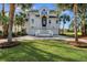 Charming two-story home with a well-manicured lawn, palm trees, and an inviting entrance at 9 Intracoastal Ct, Isle of Palms, SC 29451