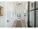 Bright hallway with white shiplap walls, wooden floors, and stylish lighting fixtures at 9 Intracoastal Ct, Isle of Palms, SC 29451