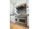 Close-up of a stainless steel Jenn-Air range with a modern backsplash and white cabinets at 9 Intracoastal Ct, Isle of Palms, SC 29451