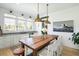 Bright kitchen with white cabinets, granite countertops, and a large rustic dining table at 9 Intracoastal Ct, Isle of Palms, SC 29451