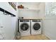 Bright laundry room with a new washer and dryer, shelves, and natural light from the window at 9 Intracoastal Ct, Isle of Palms, SC 29451