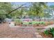 Picturesque backyard with mature trees, gravel paths, seating, and lush foliage for outdoor living and relaxation at 935 Lansing Dr, Mount Pleasant, SC 29464
