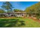Spacious backyard featuring a well-maintained lawn, mature trees, a charming pergola, and a cozy seating area at 935 Lansing Dr, Mount Pleasant, SC 29464