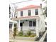 Charming two-story home featuring a red metal roof, welcoming front porch, and beautiful flower beds at 10 Killians St, Charleston, SC 29403