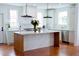 Spacious kitchen features a large island with marble countertop, stainless steel appliances and hardwood floors at 10 Killians St, Charleston, SC 29403