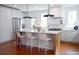 Bright kitchen featuring stainless steel refrigerator, sleek white cabinetry, and marble countertop island with seating at 10 Killians St, Charleston, SC 29403