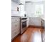 Bright kitchen featuring stainless steel range, custom cabinets, marble counters, and hardwood floors at 10 Killians St, Charleston, SC 29403