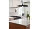 Bright kitchen featuring stainless steel oven, sleek white cabinetry, and marble countertop island with range hood at 10 Killians St, Charleston, SC 29403