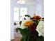Close-up of flowers with a view into the living room with bright light from large windows at 10 Killians St, Charleston, SC 29403