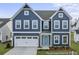 Charming two-story home featuring a blue exterior, a white garage door, and a well-manicured front lawn at 1005 Toland Dr # 44P, Saint George, SC 29477