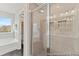 Bright bathroom featuring glass shower doors, gray-toned tile, and a soaking tub under a window at 1007 Toland Dr # 45P, Saint George, SC 29477