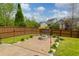 Charming backyard fire pit area with stone surround, lush landscaping, and privacy fencing at 106 Gathering Island Rd, Summerville, SC 29485