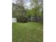 Backyard with a combination of wooden and white fences surrounded by mature trees and greenery at 108 Sandlewood Dr, Summerville, SC 29483