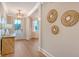 Entryway with decorative woven mirrors, wood-look floors, and a transom window at 112 Coastline St, Ridgeville, SC 29472