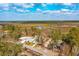 Scenic aerial view of a beautiful home surrounded by trees and marshland under a bright sky with puffy clouds at 116 Peninsula Dr, Ravenel, SC 29470