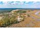 Expansive aerial view of a beautiful home surrounded by marshland, rivers, and lush green trees under a sunny sky at 116 Peninsula Dr, Ravenel, SC 29470