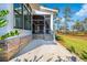 Screened-in back porch with brick flooring, access to the backyard, and views of marshland at 116 Peninsula Dr, Ravenel, SC 29470