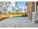 Exterior view of a home's backyard and marsh with well-maintained landscaping and a concrete patio at 116 Peninsula Dr, Ravenel, SC 29470
