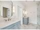 Stylish bathroom featuring dual vanities, elegant mirrors, and a glass-enclosed shower at 116 Peninsula Dr, Ravenel, SC 29470