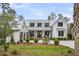 Charming white farmhouse-style exterior with a metal roof, double-door entry, and well-maintained landscaping at 116 Peninsula Dr, Ravenel, SC 29470