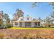 Exterior view of a large house with a screened-in porch and well-maintained yard with plenty of space at 116 Peninsula Dr, Ravenel, SC 29470