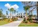 Charming exterior view of a pristine white home with lush green grass, manicured landscaping and palm trees in the yard at 116 Peninsula Dr, Ravenel, SC 29470
