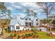 An exterior elevation of a 2-story white farmhouse with metal roof, manicured lawn, and mature trees at 116 Peninsula Dr, Ravenel, SC 29470